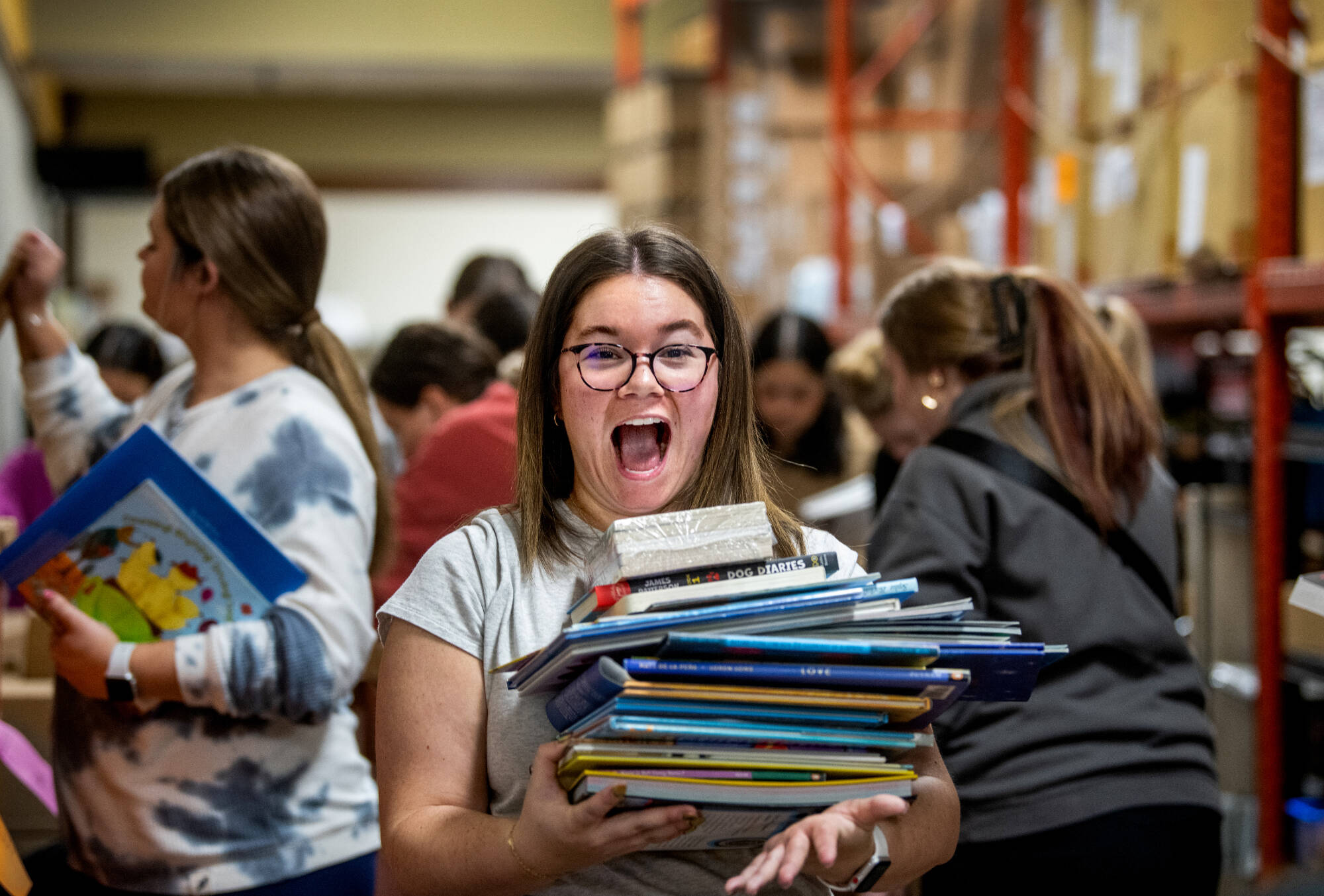 Rhianna Furness, a senior special education major, reacts to the stack of books she picked out. The Michigan Literacy Program helps new teachers from GVSU stock their classrooms with books, free of charge. CECI professor Megan Freudigmann helps operate...